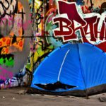 Stock photo of a tent erected in front of a graffiti-covered wall.