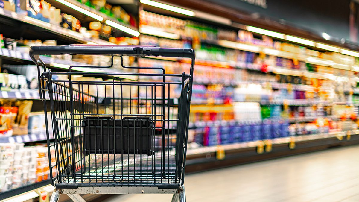 Shopping cart on the background of shop shelves in a supermarket