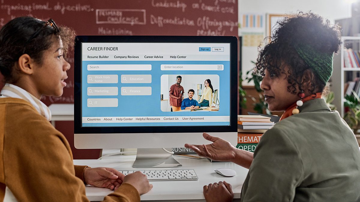 Side view of two students of color discussing career opportunities in college classroom