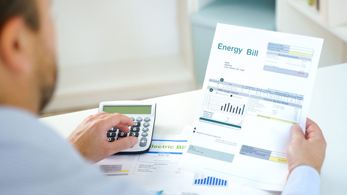 Man calculating home electricity expenses and bill statement document