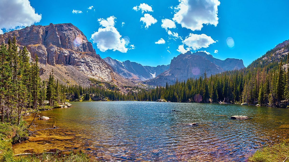 Photographer in Rocky Mountains The Noch lake with mountains pan